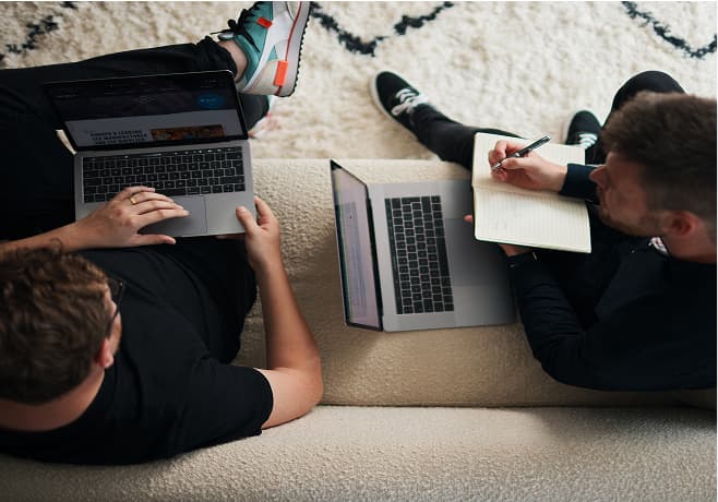 people with laptops on a sofa