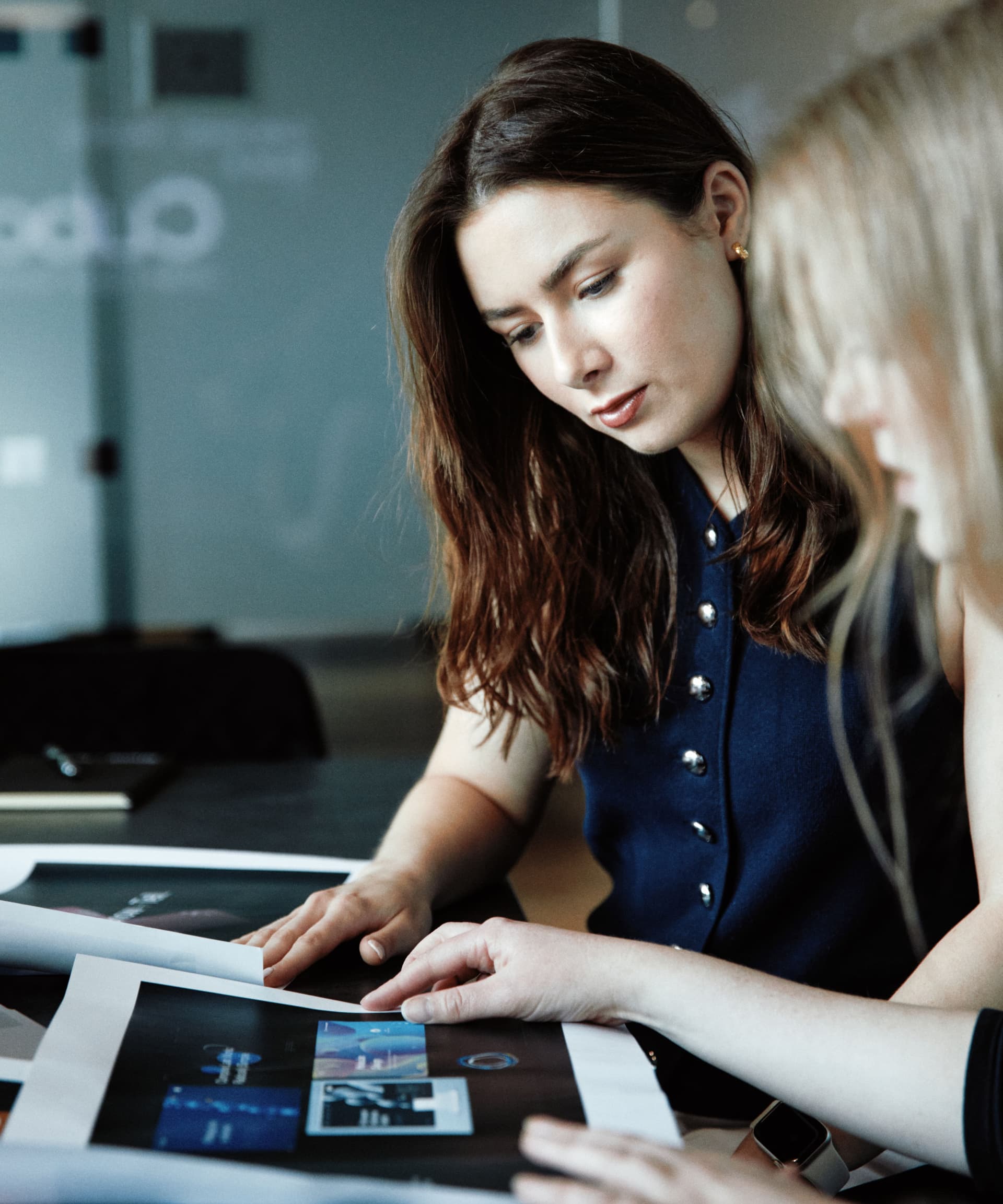 A designer studies various concept drafts, evaluating layout and visual direction.